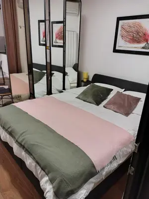 a bedroom with a large bed with two pillows at Urban Elegance SPA Studio in Niš