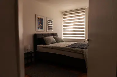 a small bedroom with a bed with a window at WellNest Niš Self Check-in & Parking I Moderan, miran apartman plus radni kutak in Niš