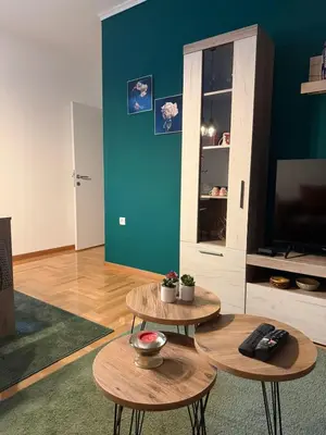 a living room with two tables and a television at Nest24- cozy apartment with terrace and private garage in Niš