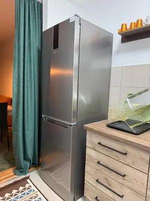 a stainless steel refrigerator in a kitchen next to a counter at Nest24- cozy apartment with terrace and private garage in Niš