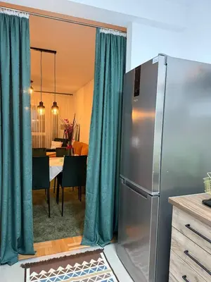 a kitchen with a refrigerator and a dining room at Nest24- cozy apartment with terrace and private garage in Niš