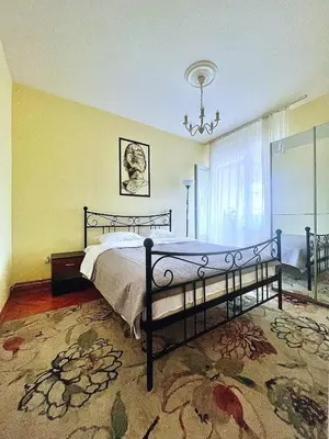 a bedroom with a bed and a chandelier at City Fontana in Kruševac