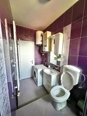 a purple bathroom with a toilet and a sink at City Fontana in Kruševac