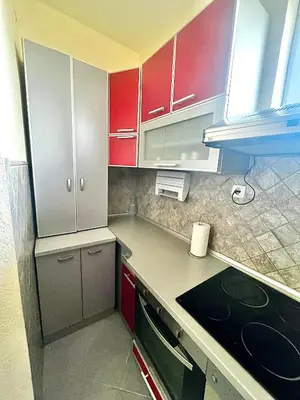a kitchen with red cabinets and a counter top at City Fontana in Kruševac