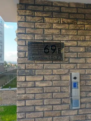 a sign on the side of a brick wall with a meter at Bagdala apartman Krusevac in Kruševac