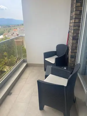 a balcony with two chairs and a table and a window at Bagdala apartman Krusevac in Kruševac
