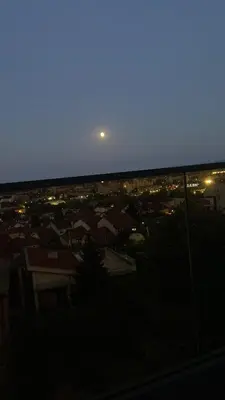 a view of a city at night with a moon at Bagdala apartman Krusevac in Kruševac