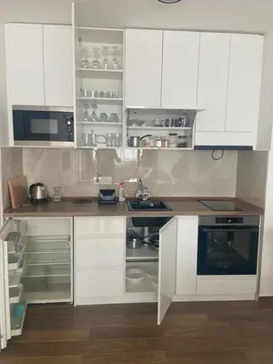a white kitchen with white cabinets and a microwave at Bagdala apartman Krusevac in Kruševac