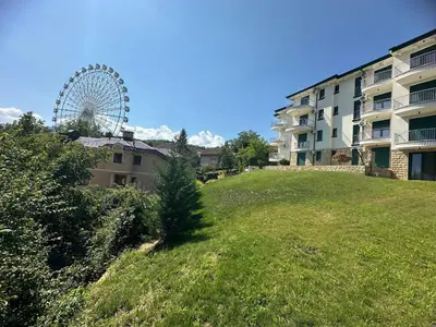 a ferris wheel on a hill next to a building at Lux stay in Vrnjacka Banja C3 in Vrnjačka Banja
