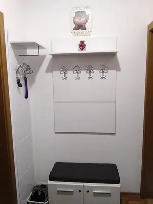 a bathroom with a white wall with a toilet at Studio apartman BB4 in Vrnjačka Banja