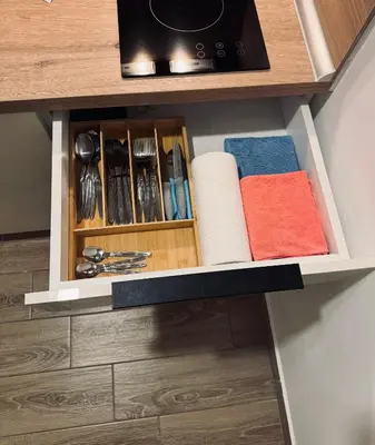 a drawer in a cabinet with towels and utensils at Hafsah Hill Kopaonik in Kopaonik
