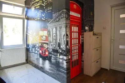 a red phone booth painted on a wall with a picture of a street at Apartman Sanja in Džavarci
