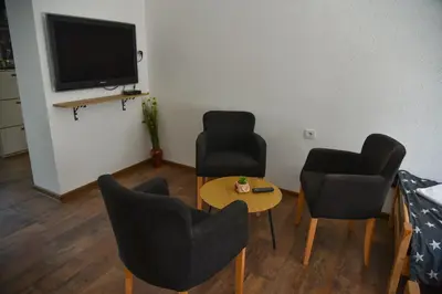 a living room with two chairs and a table and a tv at Apartman Sanja in Džavarci
