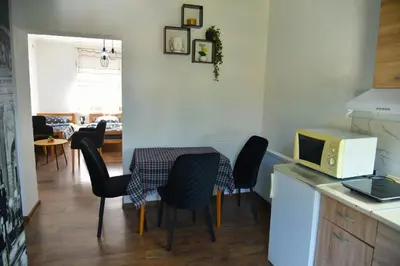 a kitchen with a table with chairs and a microwave at Apartman Sanja in Džavarci