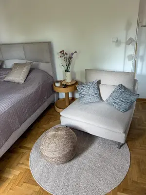 a room with a bed and a chair and a table at Apartman 7 in Vrnjačka Banja