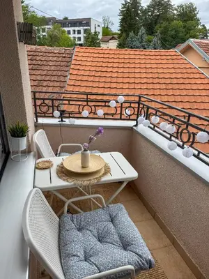 a small patio with a table and chairs on a balcony at Apartman 7 in Vrnjačka Banja