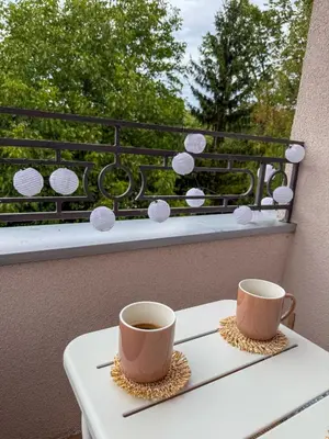 two cups of coffee sitting on a table on a balcony at Apartman 7 in Vrnjačka Banja
