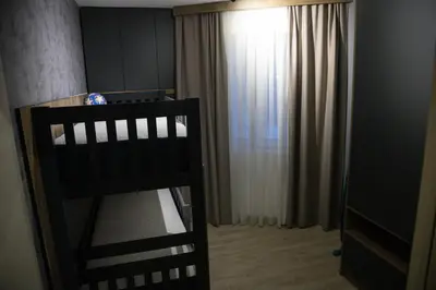 a black crib in a room with a curtain at Apartmens in Kopaonik in Kopaonik