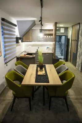 a kitchen with a wooden table and green chairs at Apartmens in Kopaonik in Kopaonik