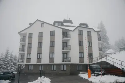 a large white building with snow on the ground at Apartmens in Kopaonik in Kopaonik