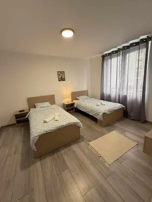 two beds in a room with wooden floors at Apartman MATEA in Pirot