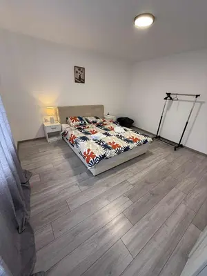a bedroom with a bed and a wooden floor at Apartman MATEA in Pirot
