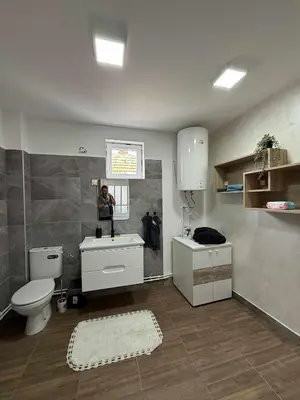 a person taking a picture of a bathroom with a toilet and sink at Apartman MATEA in Pirot