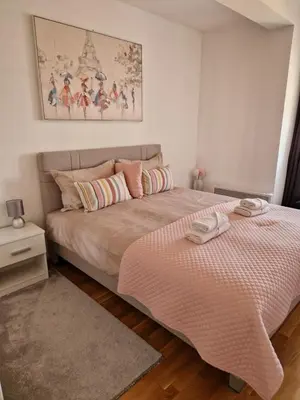 a bedroom with a large bed with a pink comforter at Apartman IRIS in Pirot