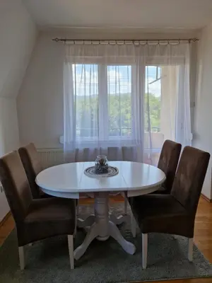 a white table and chairs in a room with a window at Apartman IRIS in Pirot