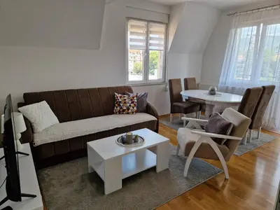 a living room with a couch and a table at Apartman IRIS in Pirot
