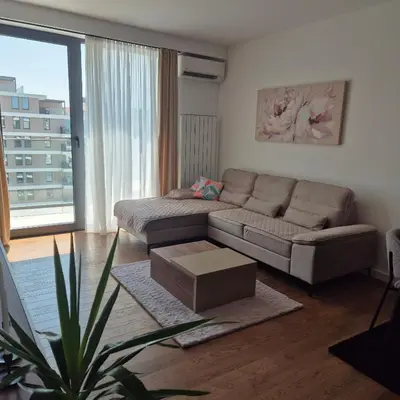 a living room with a couch and a table at V i N Boutique Apartment in Niš