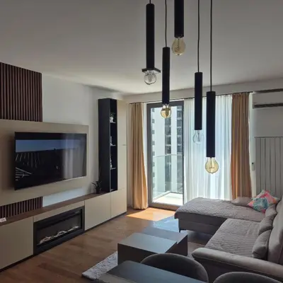 a living room with a couch and a tv at V i N Boutique Apartment in Niš