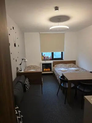 a room with two beds and a couch and a table at Snow White apartman Vila Bela reka 50m from gondola - free parking in Brzeće
