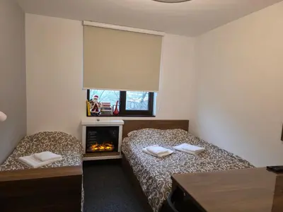a bedroom with two beds and a fireplace at Snow White apartman Vila Bela reka 50m from gondola - free parking in Brzeće
