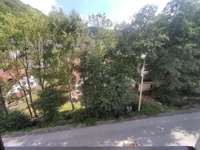 a view of a street with trees and a house at Snow White apartman Vila Bela reka 50m from gondola - free parking in Brzeće
