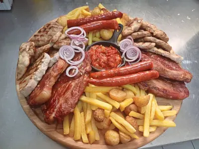 a plate of food with sausage and french fries at Motel Kruna in Despotovac