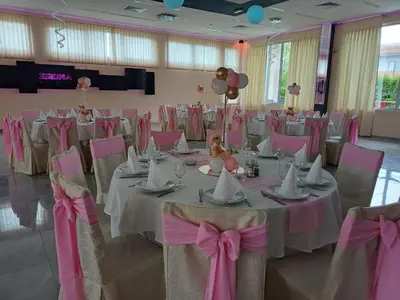 a banquet hall with tables and chairs with pink bows at Motel Kruna in Despotovac