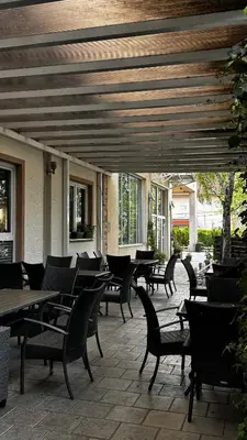a patio with tables and chairs and tables and chairs at Motel Kruna in Despotovac