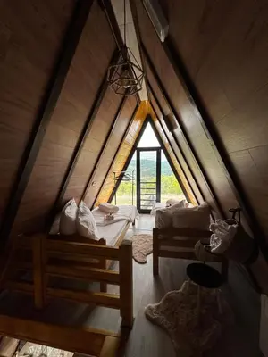 a attic room with two beds and a window at Vile NIT in Raška