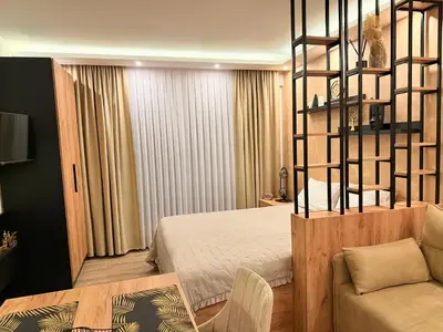 a bedroom with a bed and a couch in a room at UN lux - Residence Hill in Kopaonik