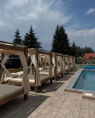 a row of wooden beds next to a swimming pool at UN lux - Residence Hill in Kopaonik