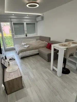 a living room with a bed and a table at Sweet home in Bor