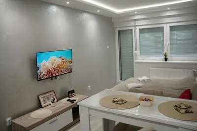 a living room with a tv on the wall at Sweet home in Bor