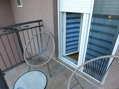 a balcony with two chairs and a fan at Aurora Lux in Vrnjačka Banja
