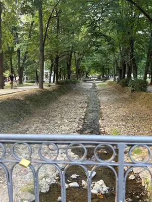 a tree lined path with a metal fence at Aurora Lux in Vrnjačka Banja