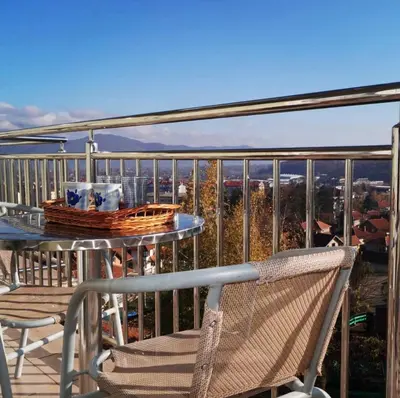 a table and chairs on a balcony with a view at Apartman PK Vrnjačka Banja in Vrnjačka Banja