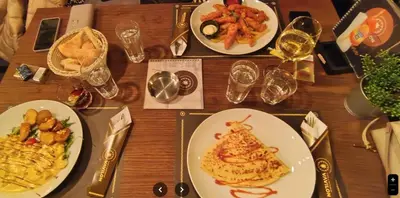 a wooden table with plates of food and glasses of wine at Modern Spacious ViS Raska Apartment! 5min Cafes in Raška