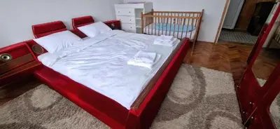 a bed with a red frame in a bedroom at Modern Spacious ViS Raska Apartment! 5min Cafes in Raška