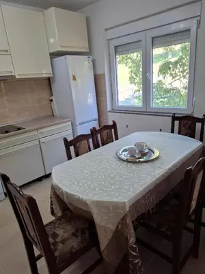 a kitchen with a table and chairs and a refrigerator at Modern Spacious ViS Raska Apartment! 5min Cafes in Raška