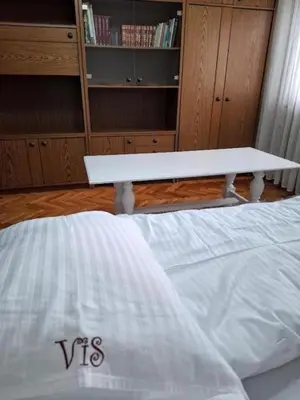 a white bed with a table in a room at Modern Spacious ViS Raska Apartment! 5min Cafes in Raška